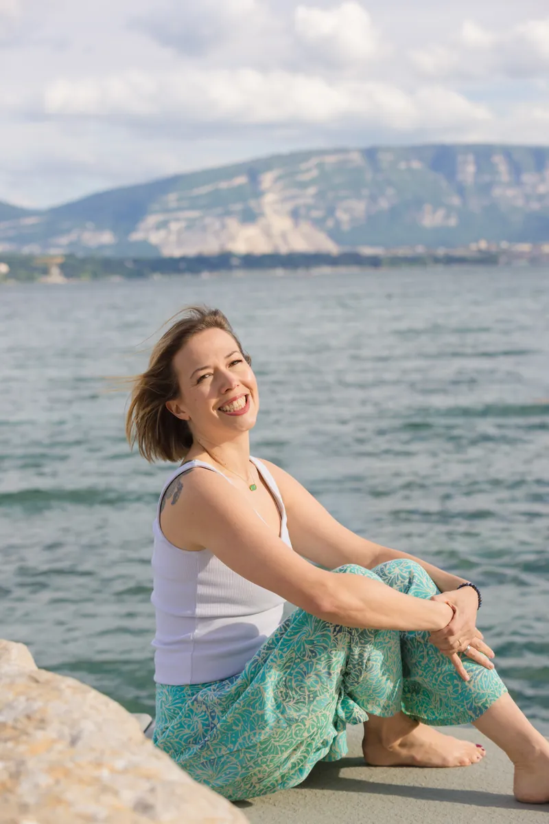 Julia Volpe, réflexologue genevoise, souriante au bord du lac Léman