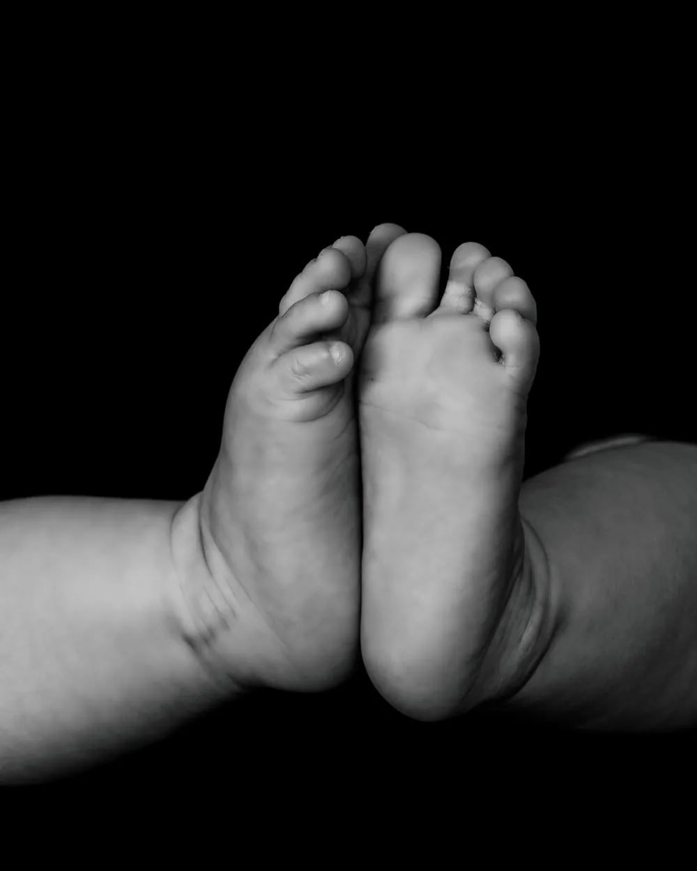 Réflexologie pour femme enceinte à Genève, future maman assise en tailleur, mains sur son ventre