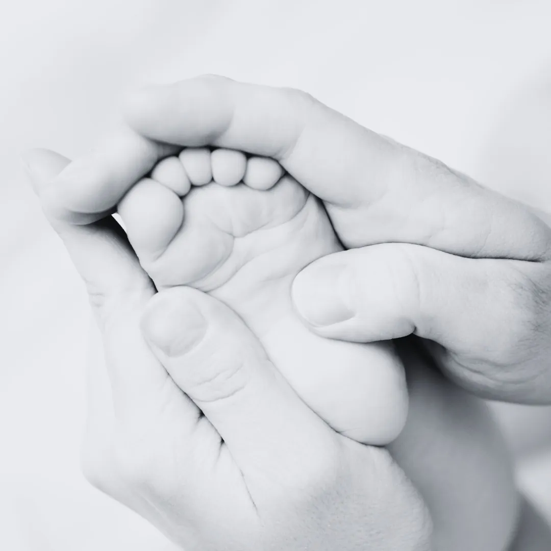 Réflexologie pédiatrique pour bébé à Bellevue, petit pied tenu délicatement dans les mains d'un adulte